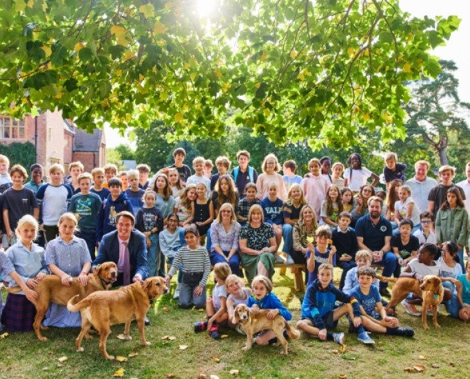 Students, teachers and dogs gathered outside on a sunny day