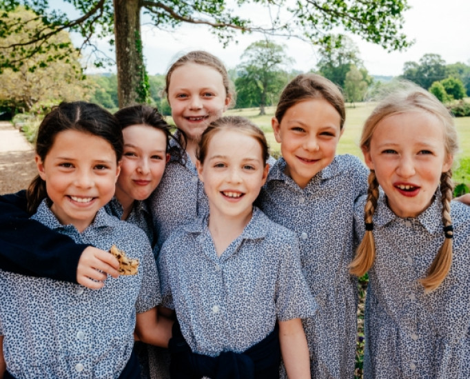 group of smiley student, one has a big, half-eaten cookie